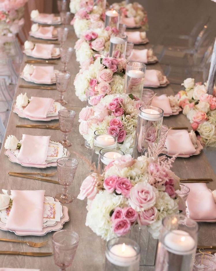 Long farm table runner of pink and white roses with blush napkins and gold flatware
