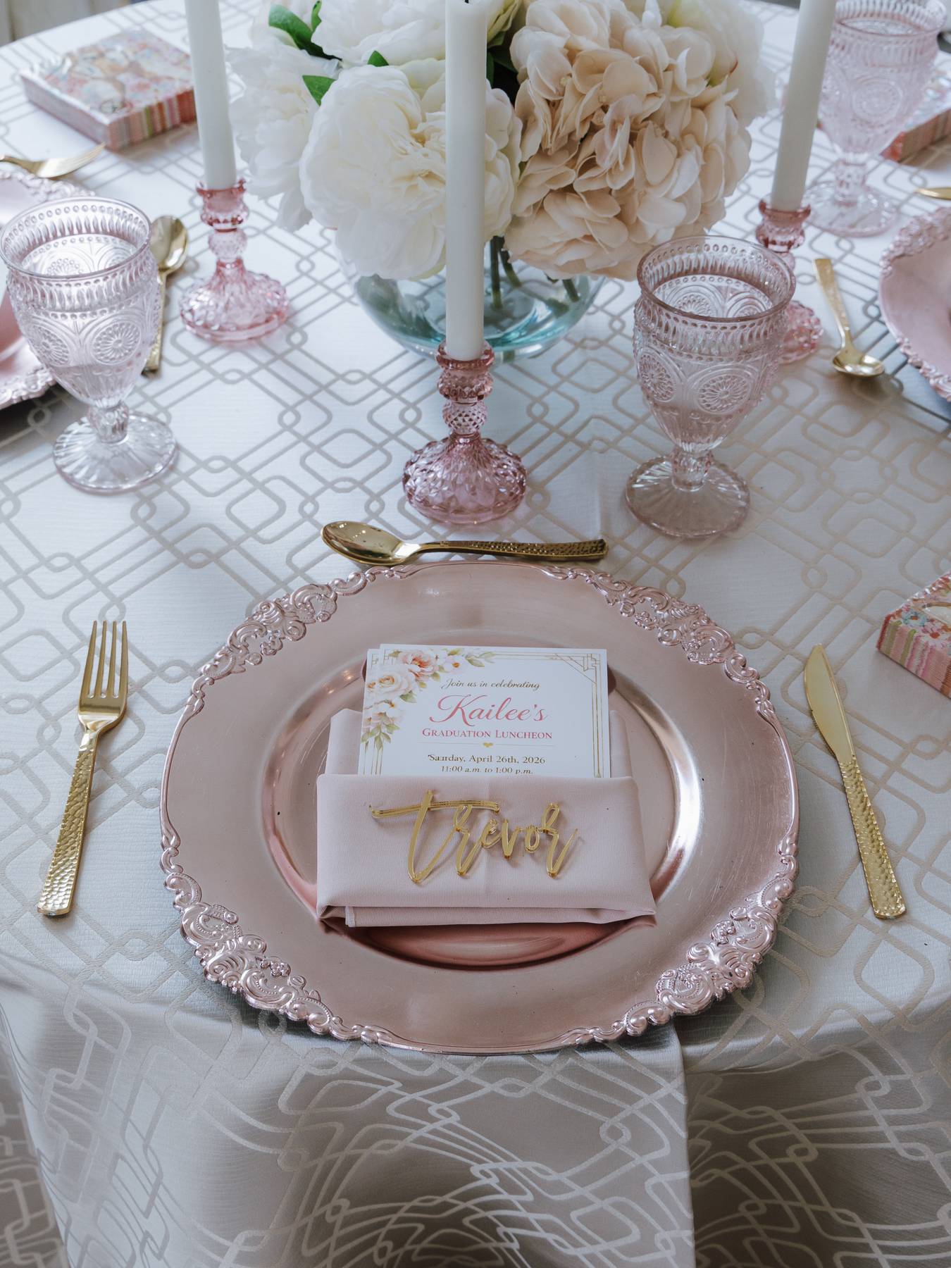Close-up of a tablescape class place setting with calligraphy name card on a rose-gold charger