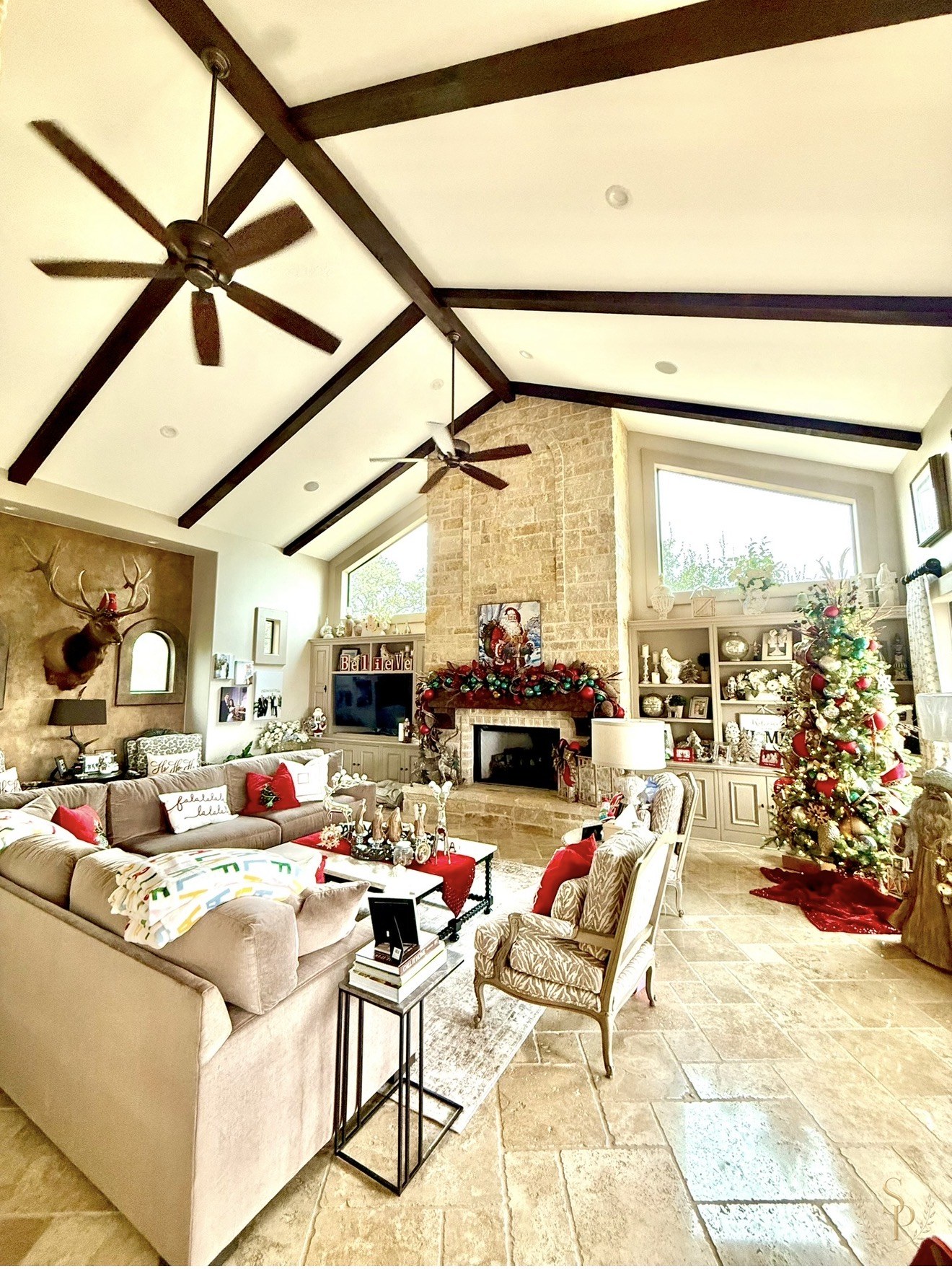 Vaulted living room with Christmas mantel styling and a glowing tree
