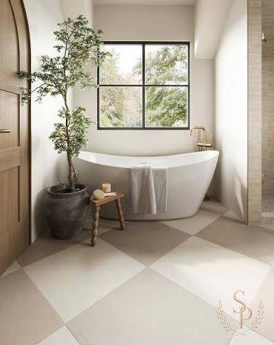 Serene bathroom with a freestanding tub, marble surround, and warm metal fixtures