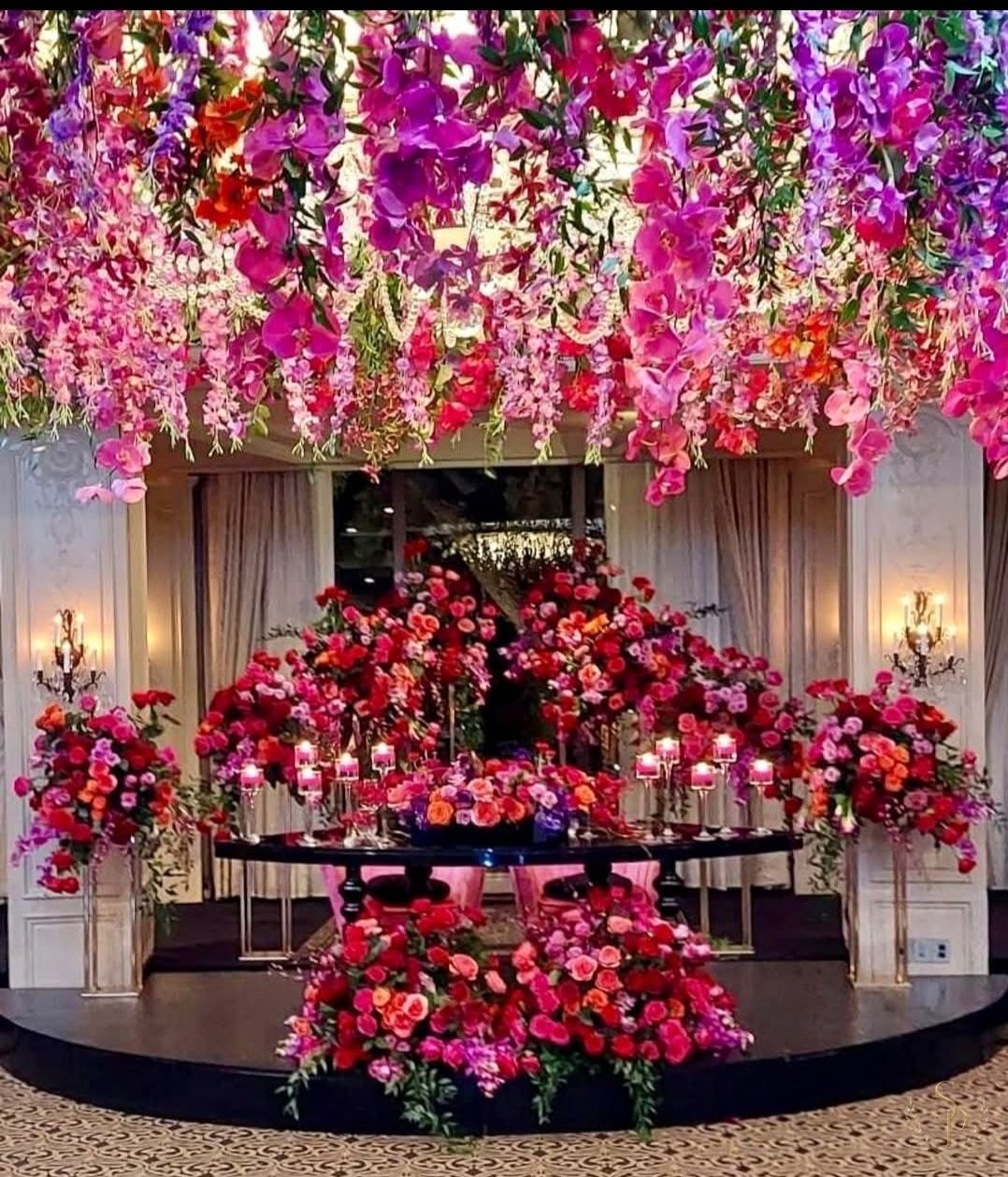 Suspended pink and purple orchid ceiling installation over a sweetheart table