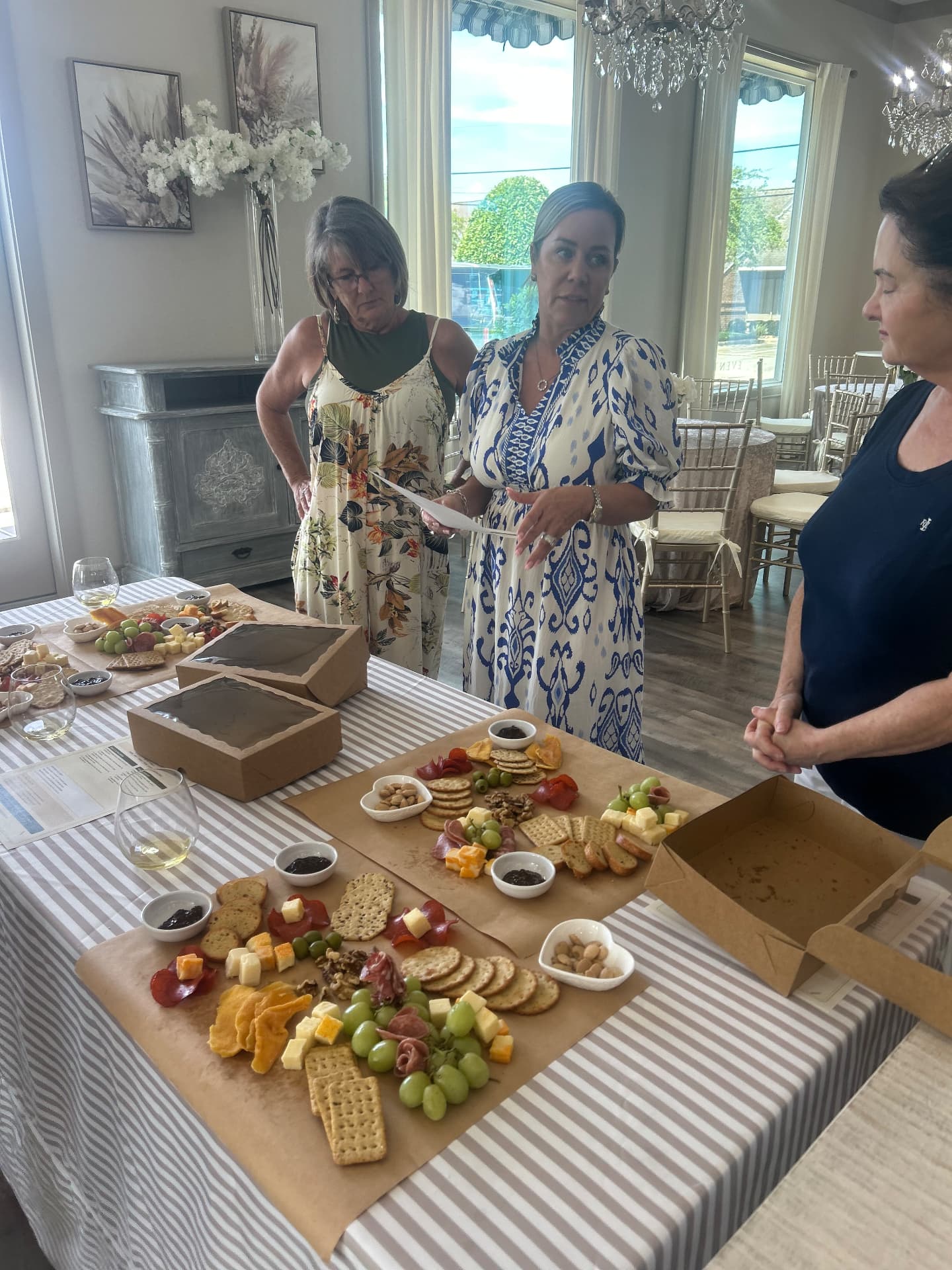 Instructor walking guests through charcuterie board styling at a workshop table