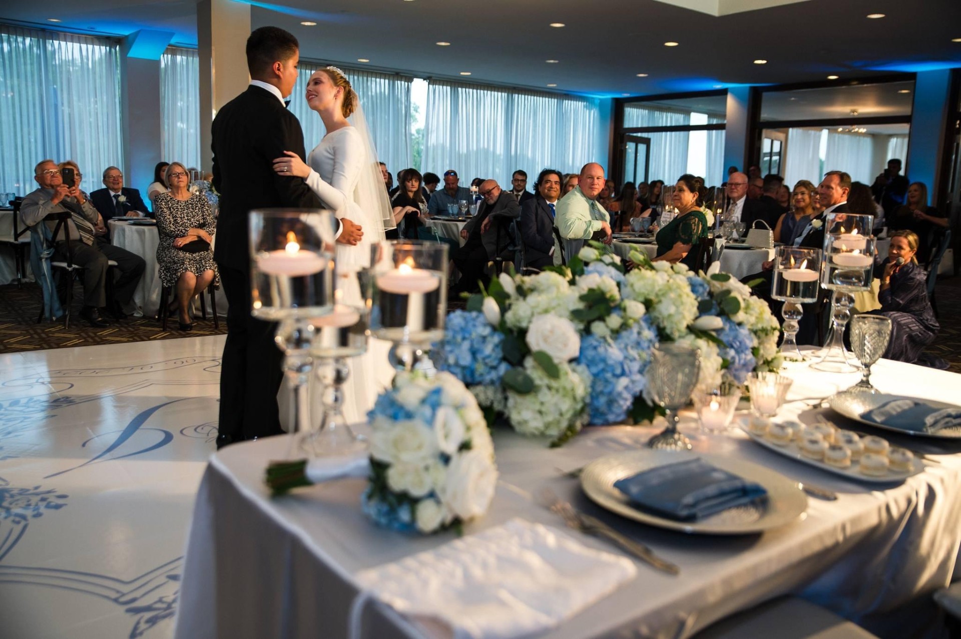 Sweetheart table with blue hydrangea garland and floating candles