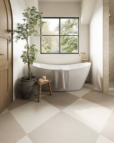 Serene bathroom with freestanding tub, checkerboard limestone floor, and a tall potted tree