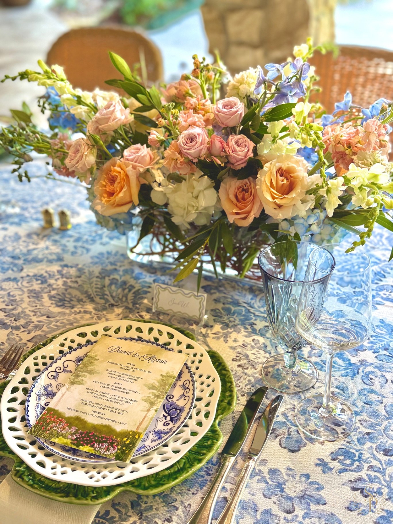 Garden-style centerpiece with peach and lavender florals on a blue chinoiserie tablecloth