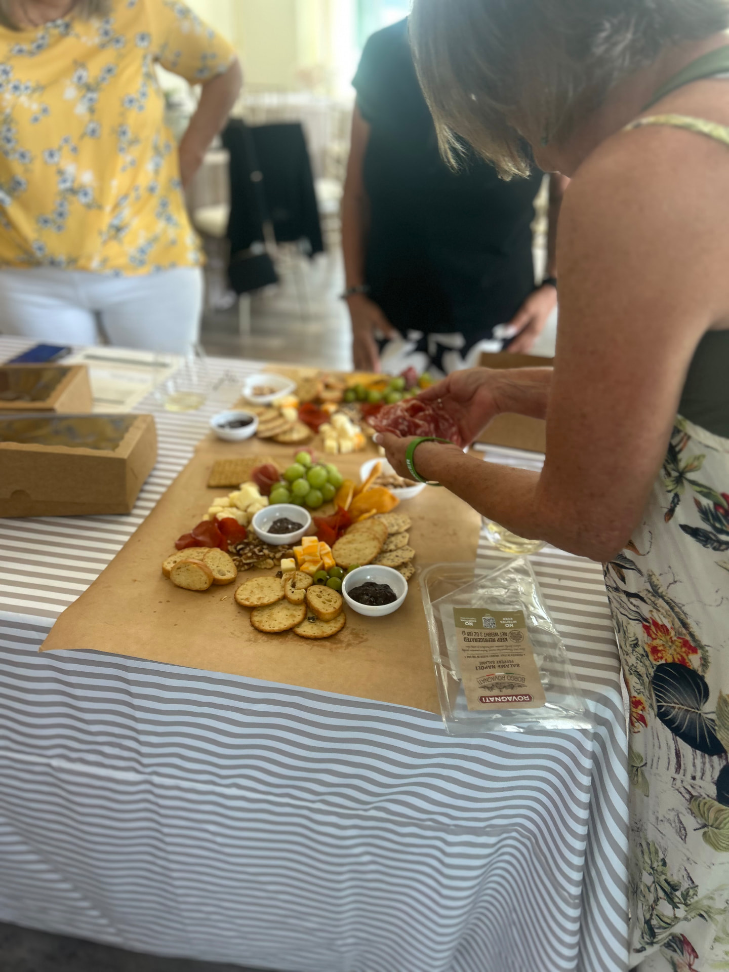 Workshop guest arranging salami rosettes on her charcuterie board