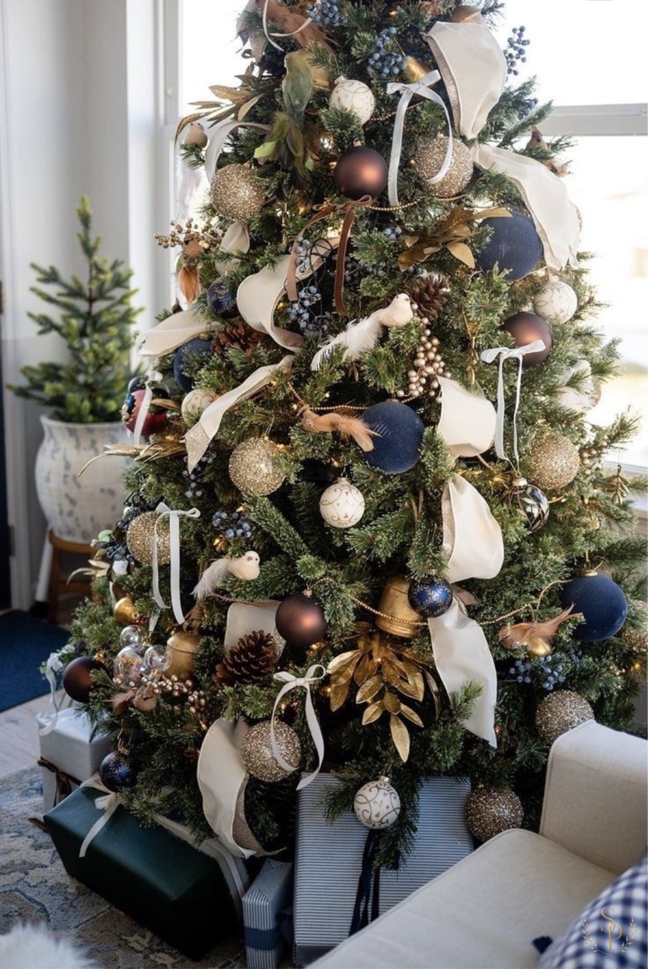 Navy, gold, and cream tree styled with ribbons, doves, and pinecones