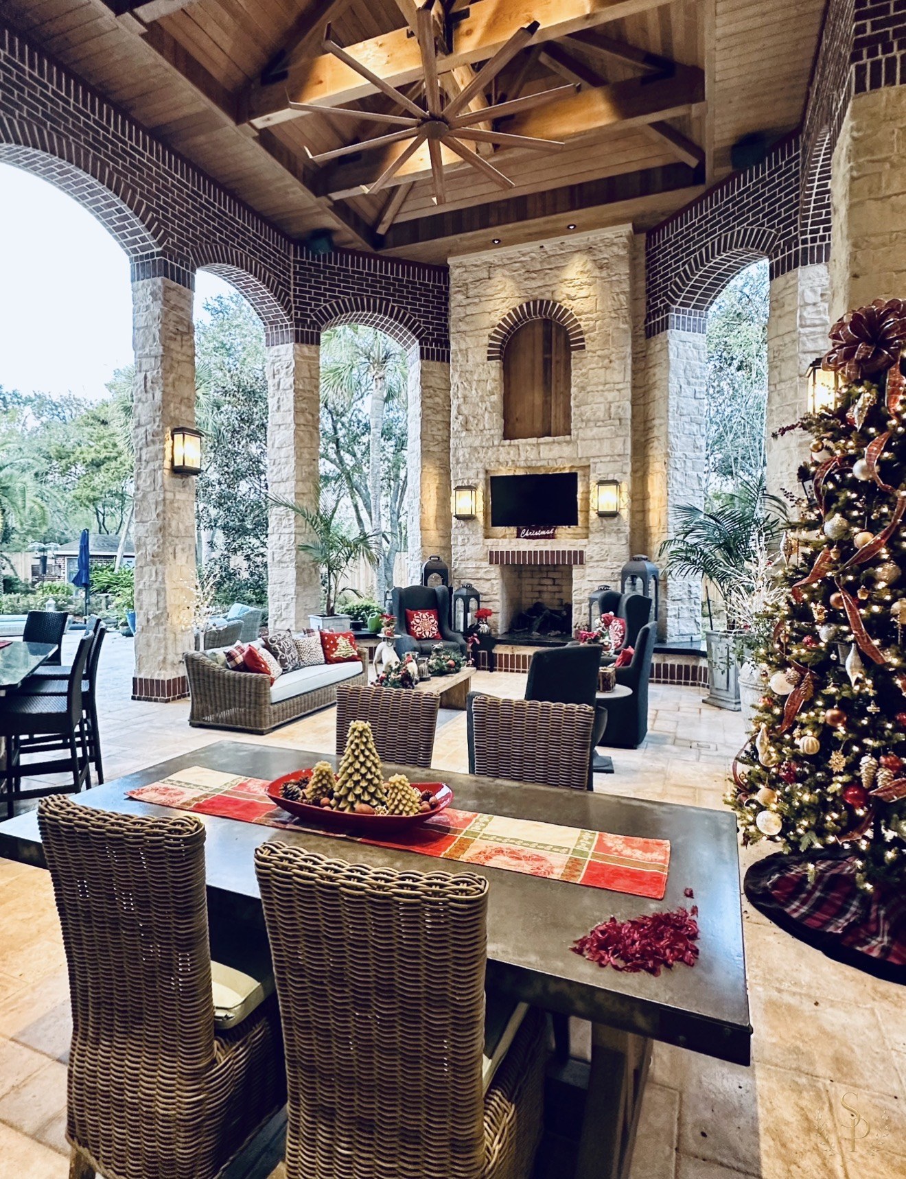 Outdoor stone loggia with a fully styled Christmas tree and tablescape
