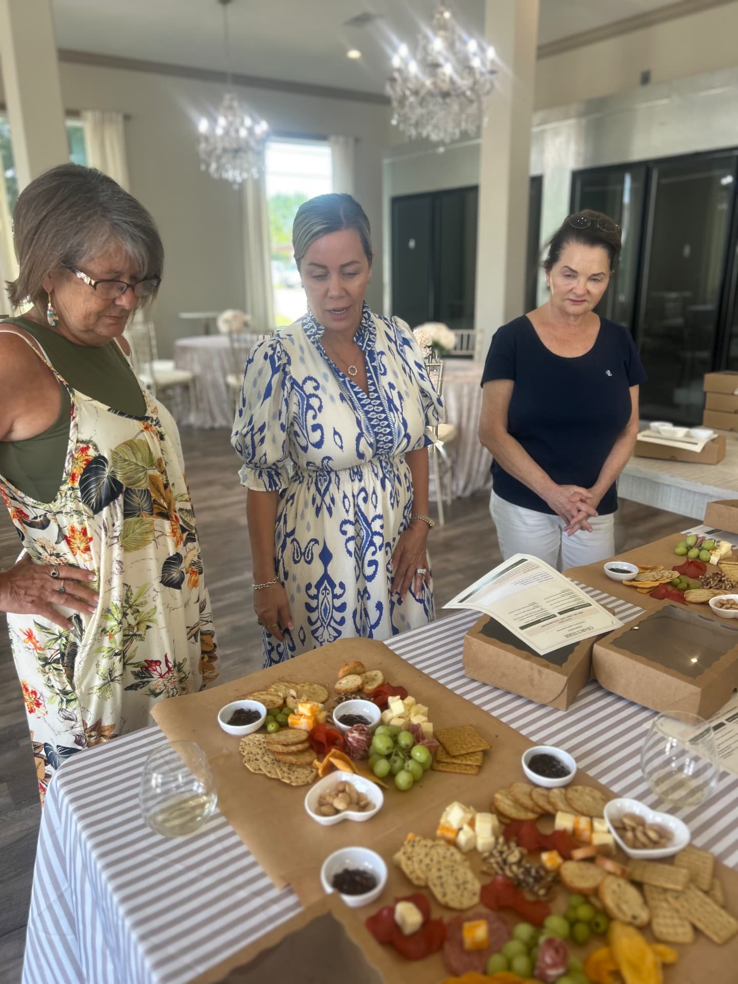 Charcuterie workshop in session with boards, wine, and printed styling guides