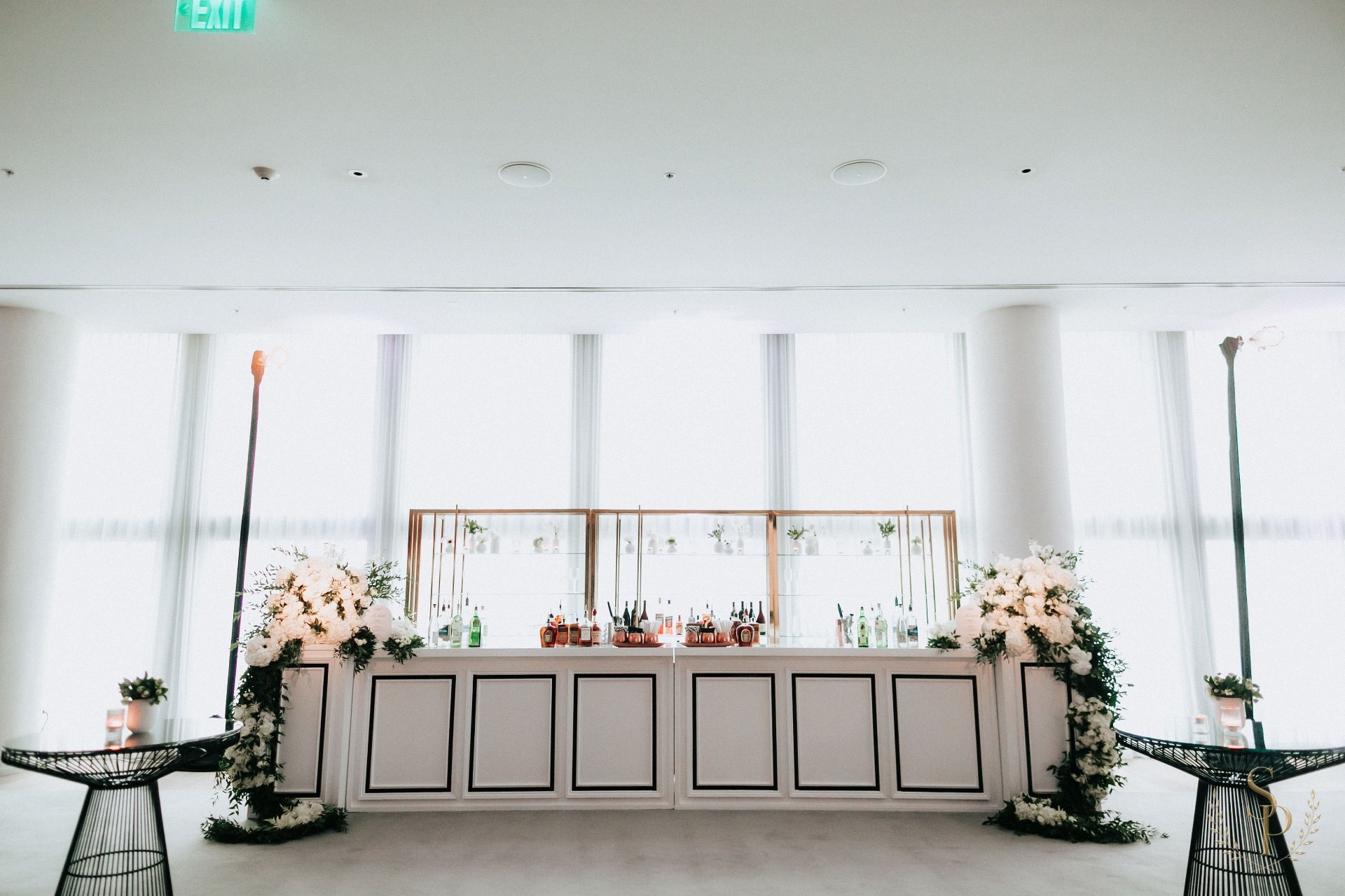 Custom white panel bar dressed with white hydrangea and rose pillars