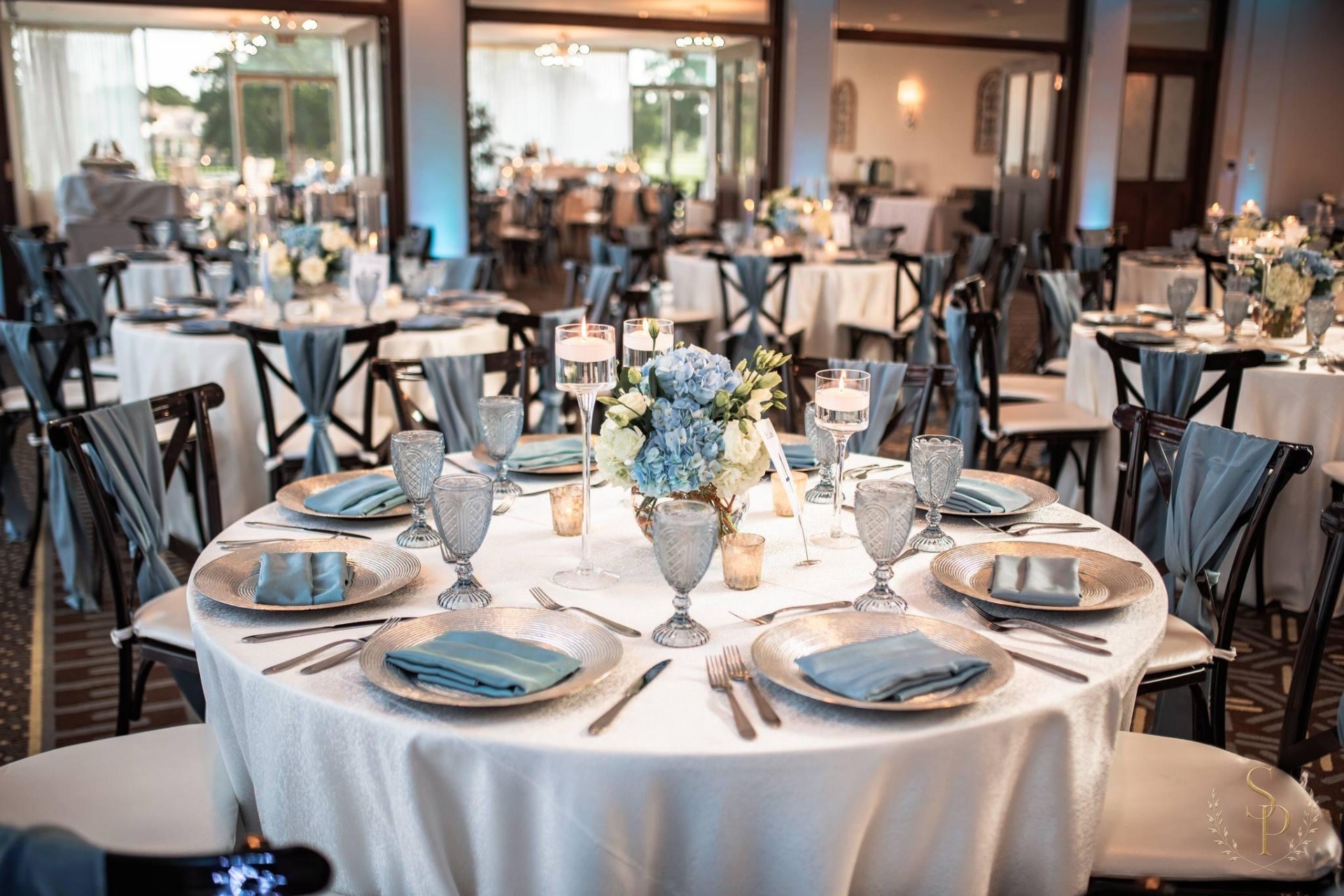 Reception tables in dusty blue and silver with hydrangea centerpieces