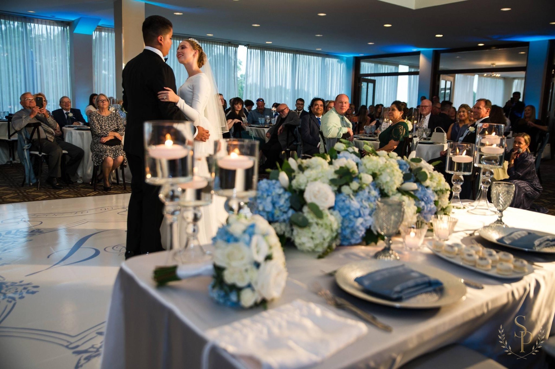 Sweetheart table with blue hydrangea garland and floating candles