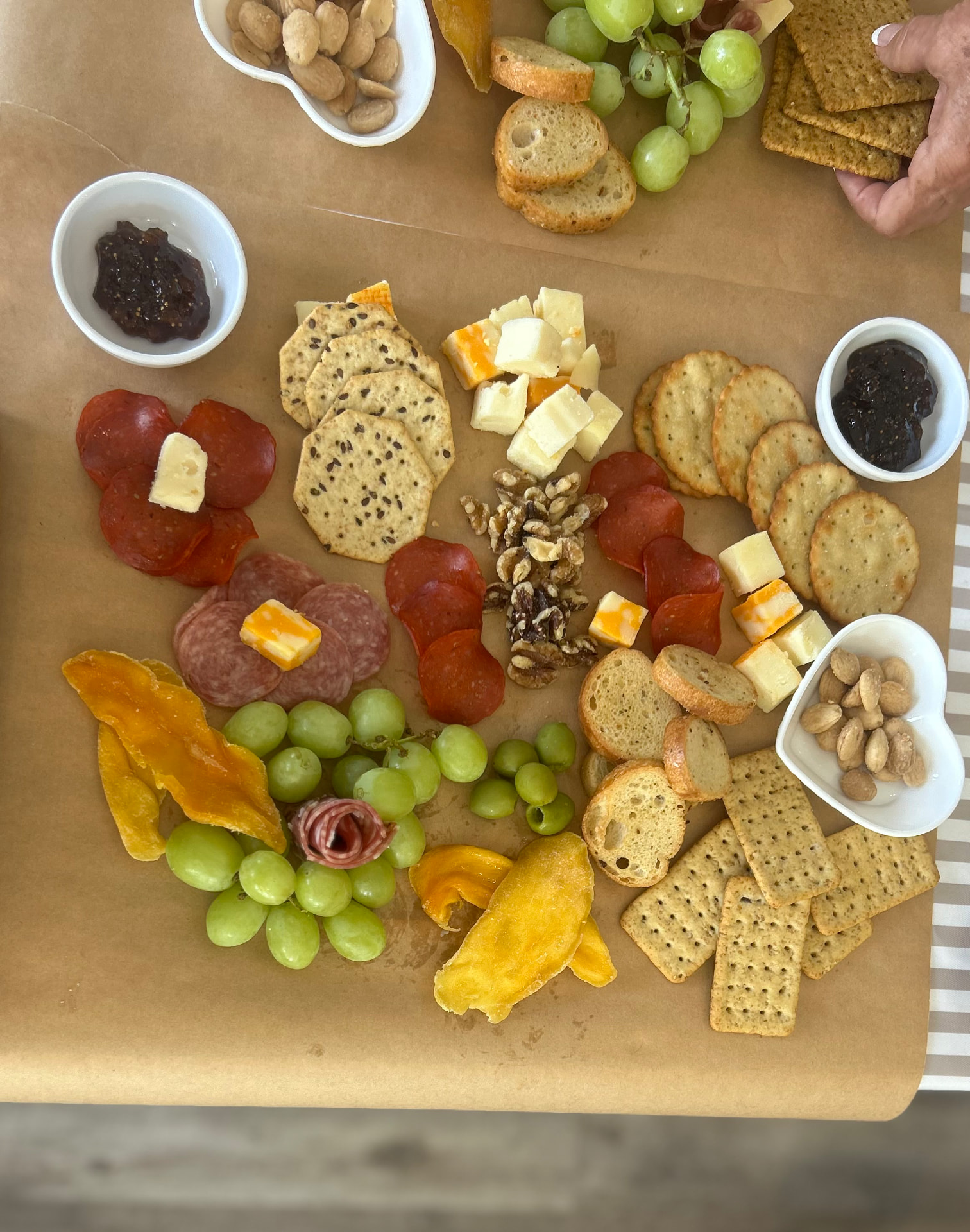 Charcuterie board from a workshop — cheeses, salami, grapes, crackers, fig jam, and marcona almonds