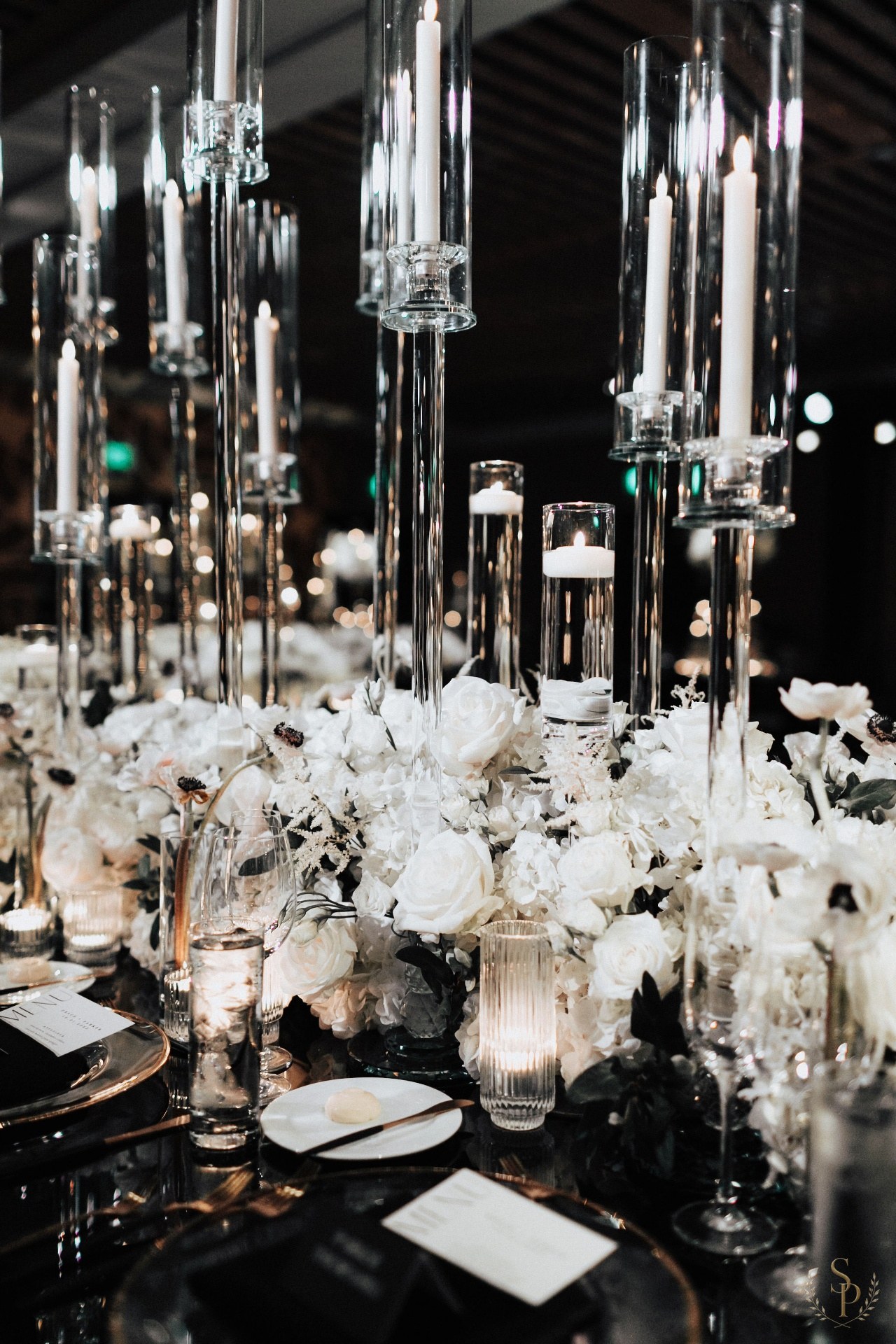 Black and white tablescape with tall crystal candelabras and white floral runner