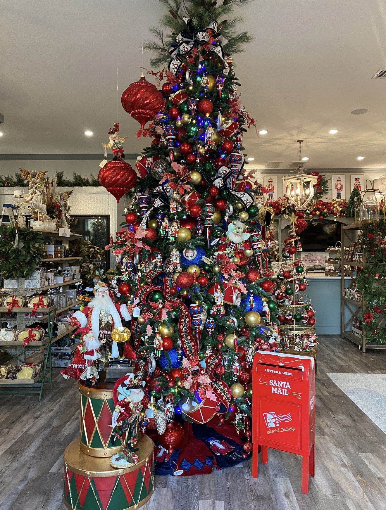 Whimsical store display tree with Santa-inspired ornaments and bright color